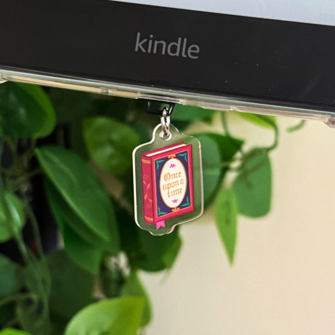 Decorative charm on a Kindle device with green leaves in the background
